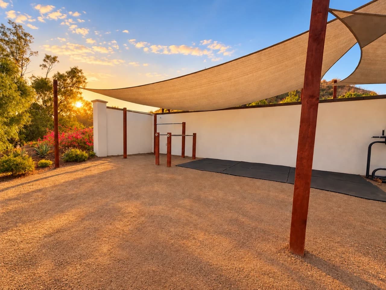 Richards fitness yard with pull-up bars and rubber mats under a shade sail
