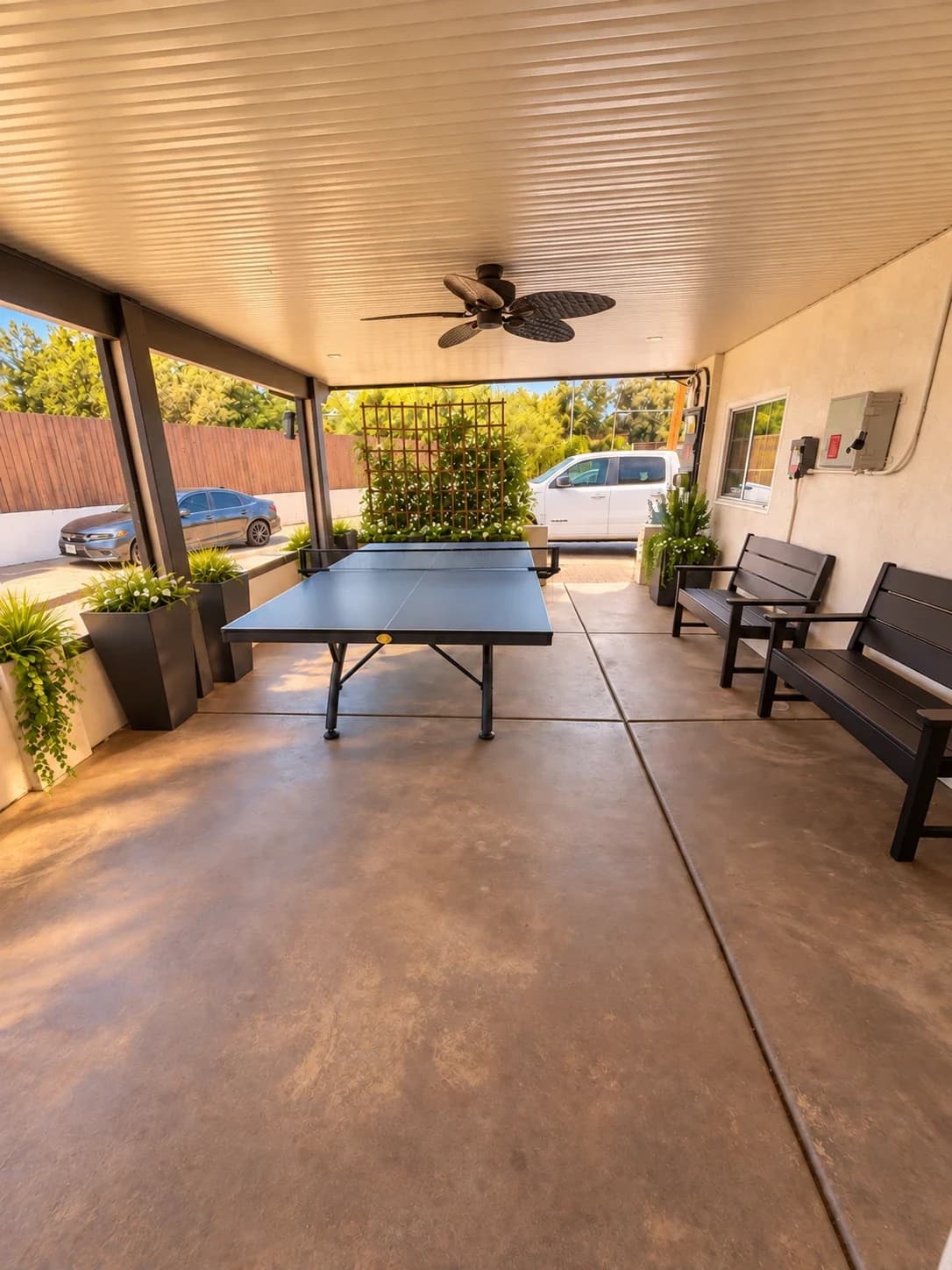 Ping-pong table, benches, and planters under the Richards covered patio