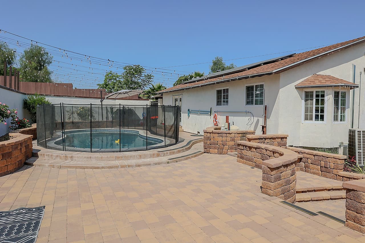 Richards single-story house with a fenced pool and paved yard