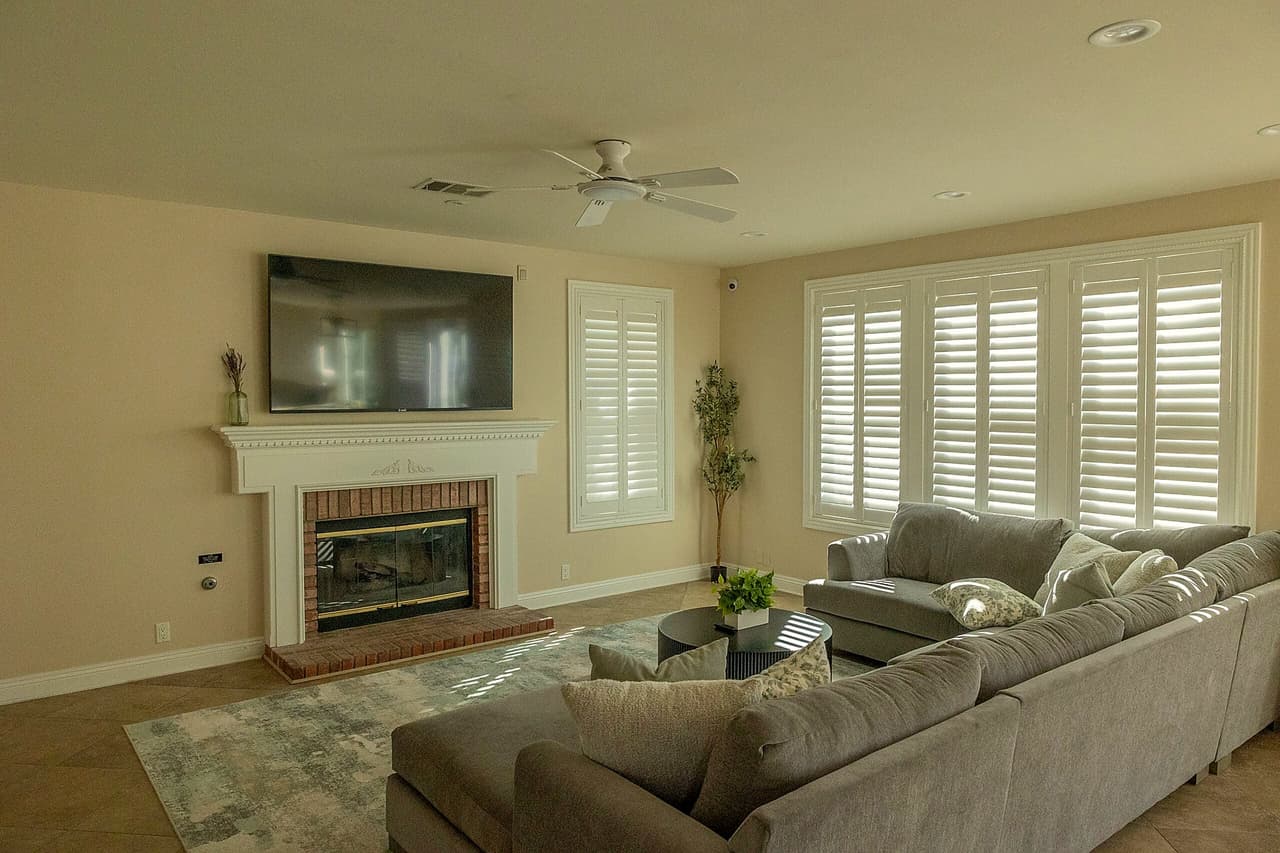 Shasta living room with a sectional, fireplace, and shuttered windows
