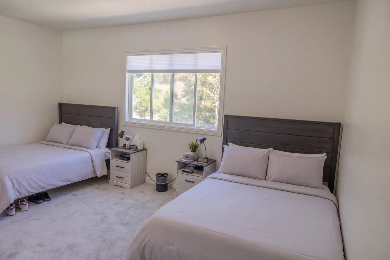 Ridgeview bedroom with two beds, nightstands, and a window