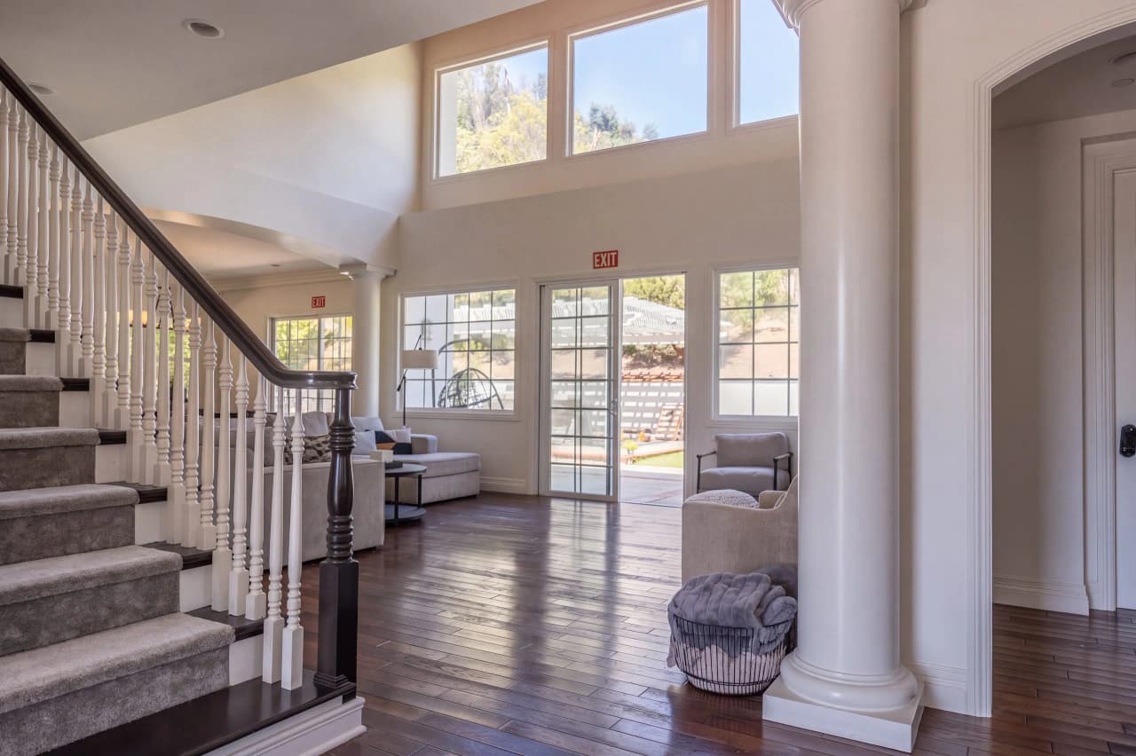 Ridgeview entry with a carpeted staircase and a column