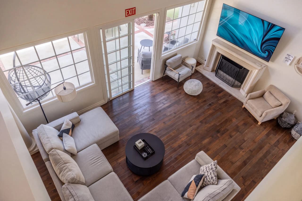 Ridgeview great room seen from the stairs, with a sectional and dark wood floors