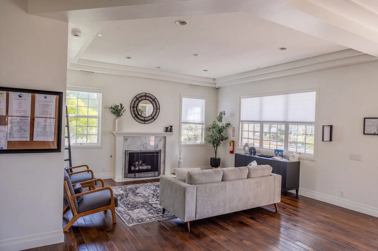 Ridgeview living room with a sofa, a marble fireplace, and a round mirror