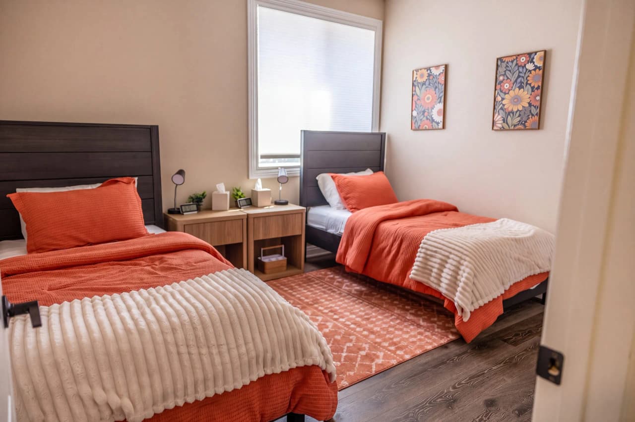 Shasta bedroom with two twin beds in coral bedding and floral prints