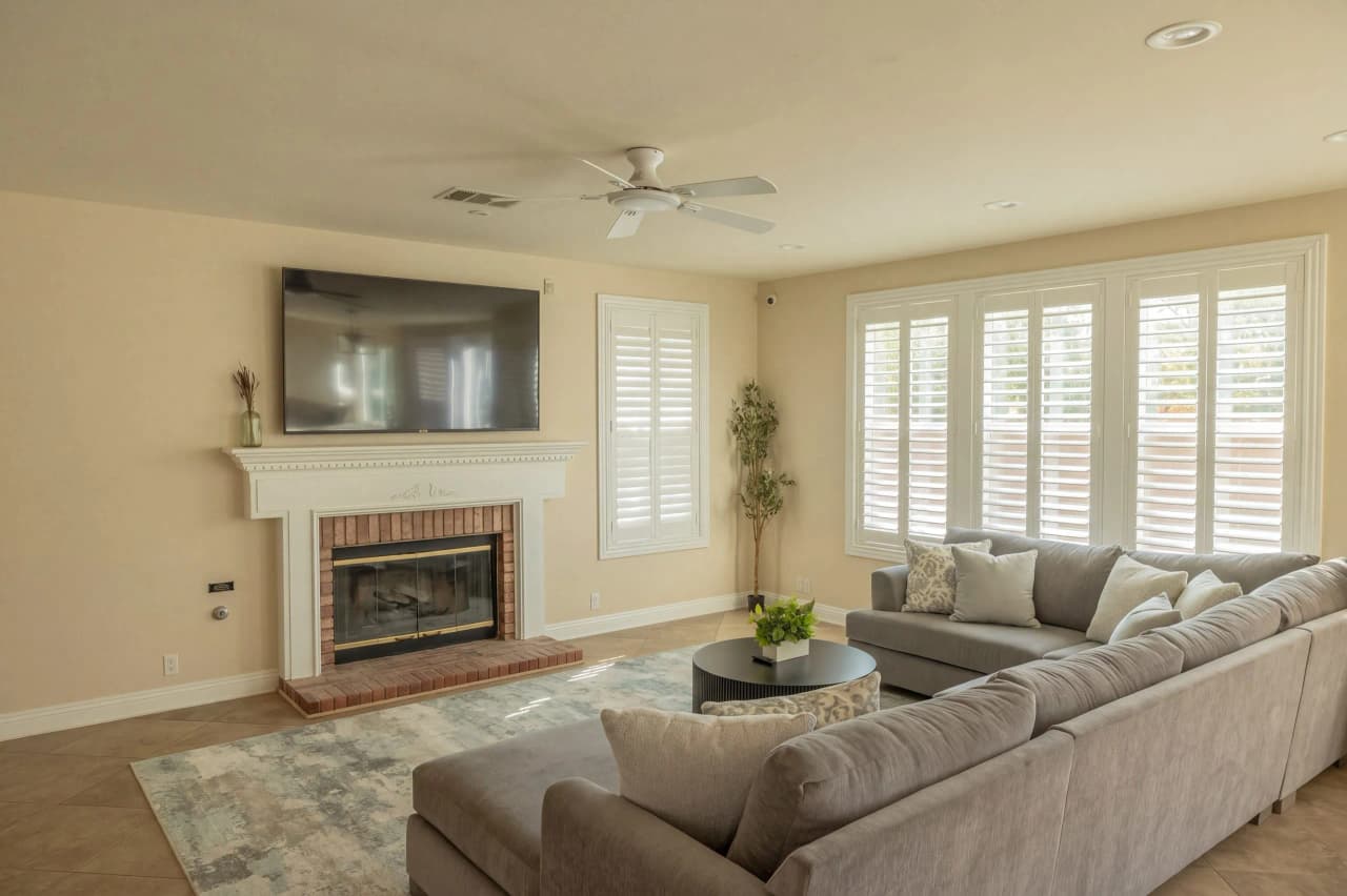 Shasta family room with a sectional sofa, fireplace, and shuttered windows