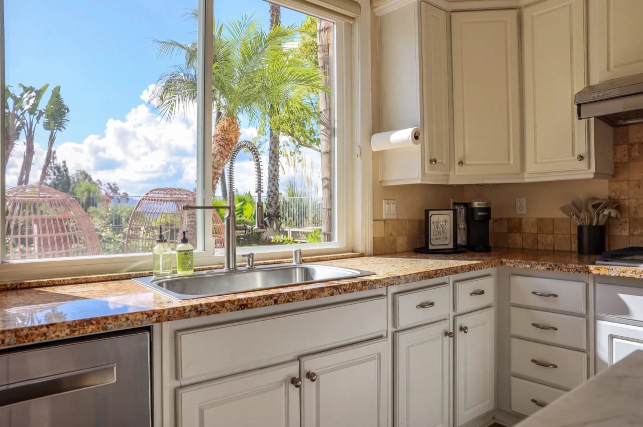 Shasta kitchen sink under a window that looks out to the backyard