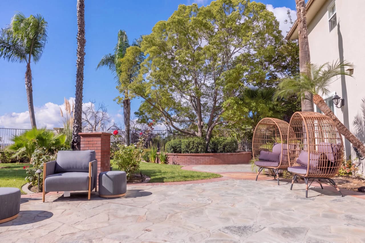 Shasta stone patio with a lounge chair and two wicker egg chairs