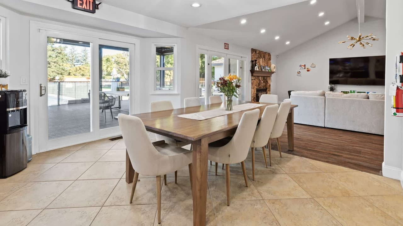 Bright dining room with wooden table and view to the patio at Hillside Horizon